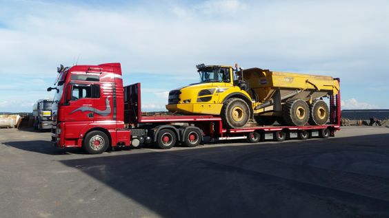 Transport av hjullaster på stor rød trailer