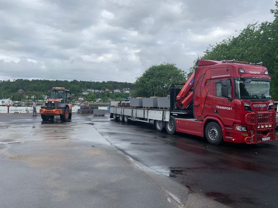 Rød trailer transport av steinblokker