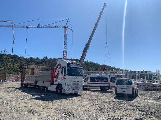 Hvit lastebil som transport av elementer på byggeplass