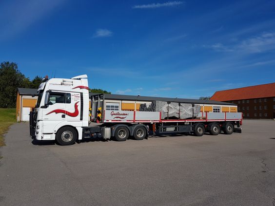 Rød trailer henger transport av steinblokker